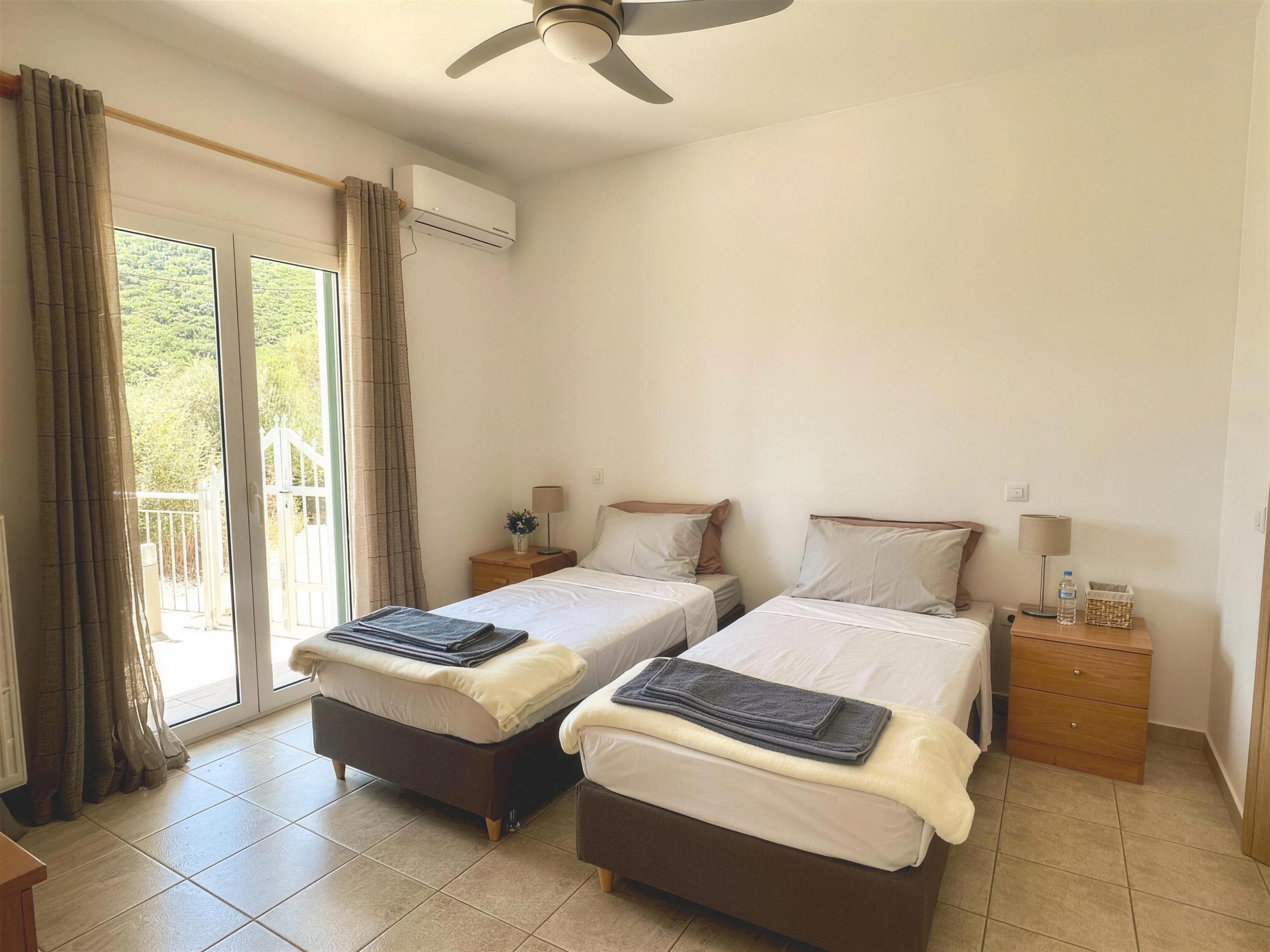 A twin room with two single beds, air conditioning and doors to the balcony