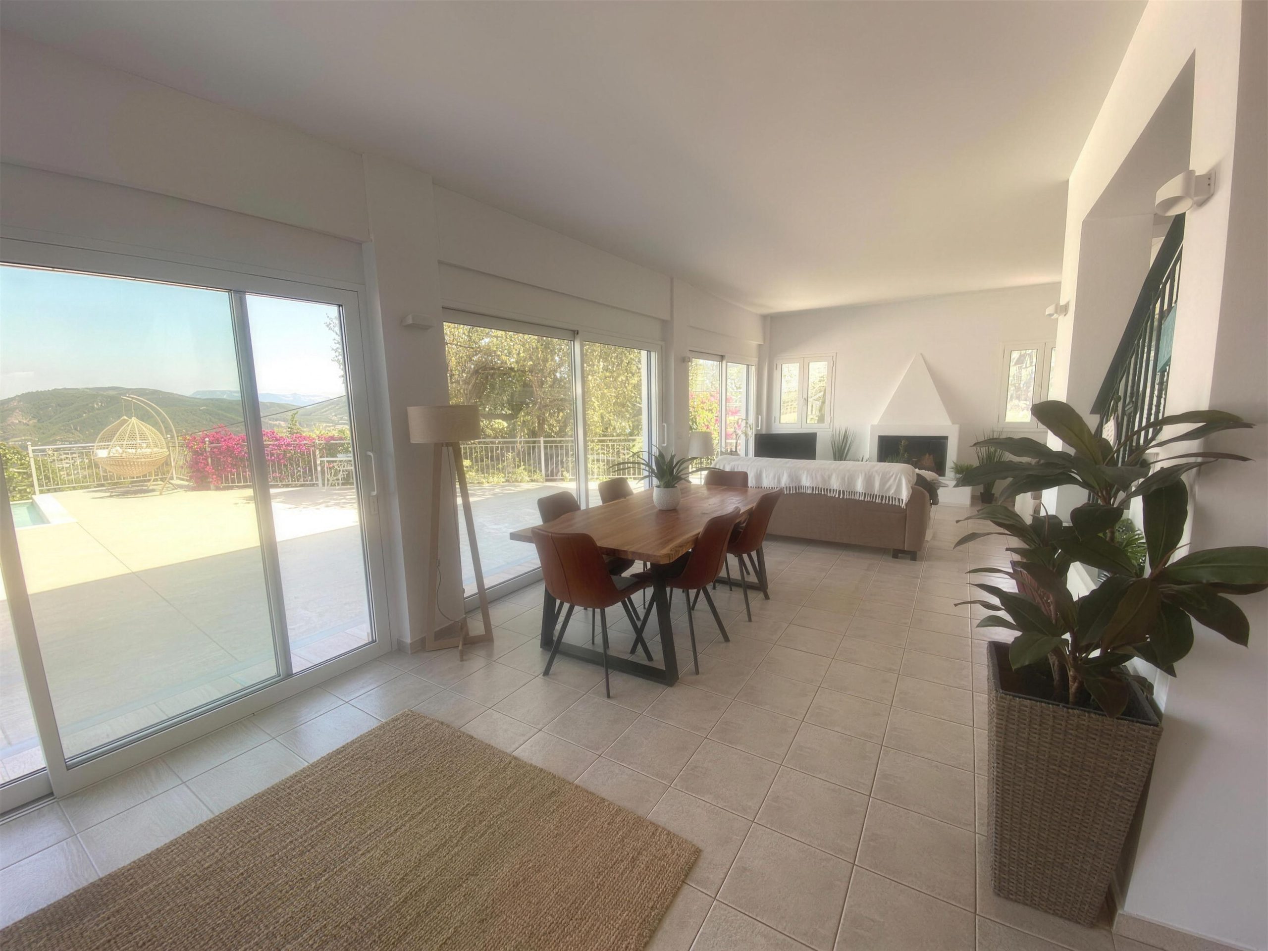 The dining table under the windows, doors to the terrace beyond