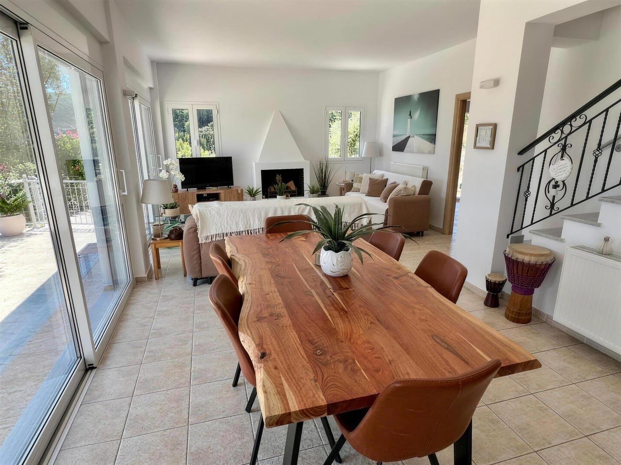 The dining table and living space, staircase and fireplace beyond