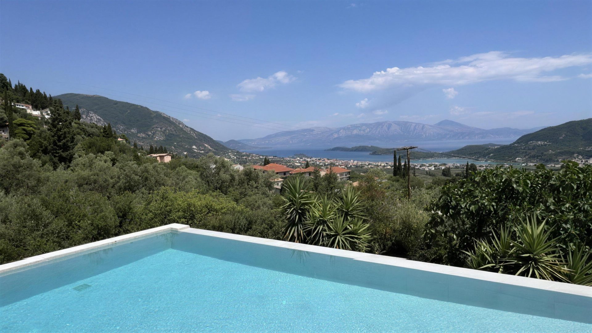 The pool's infinity edge, the town below and the bay opening out past it