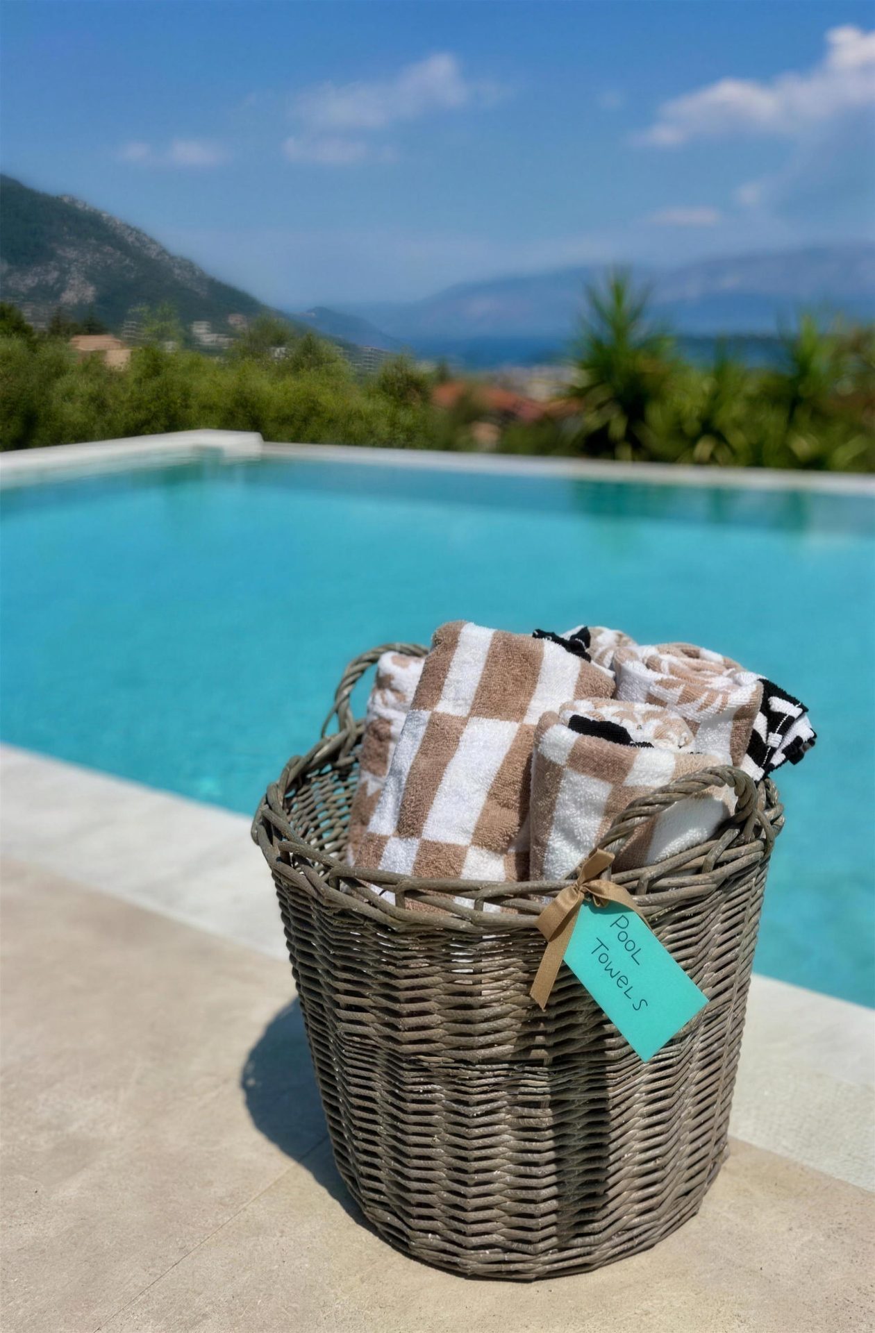 A basket of rolled beach towels set out at the pool's edge
