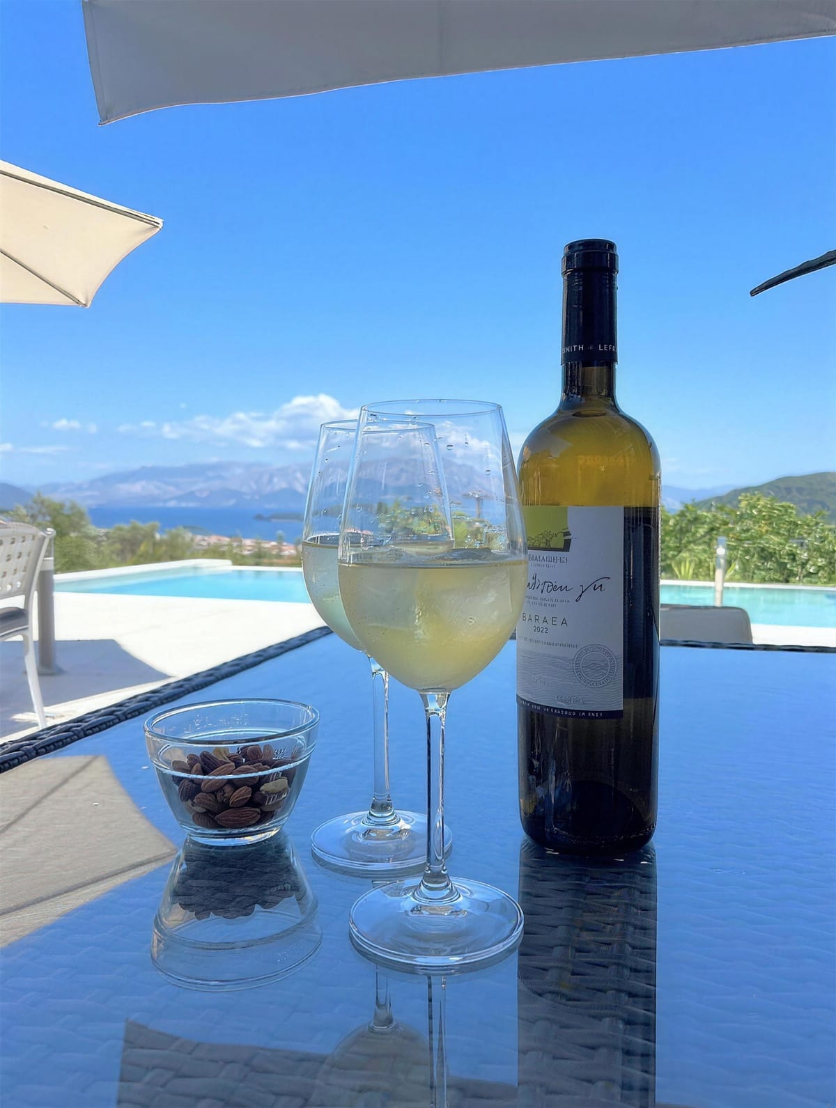 Chilled wine and olives on the pool terrace, the bay beyond